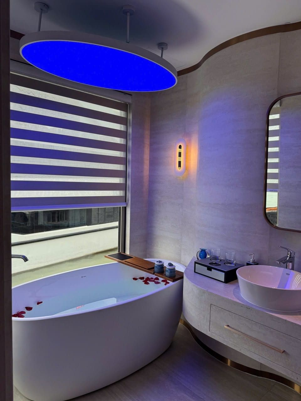 An Athena Premium cabin bathroom, freestanding tub beneath a backlit ceiling panel