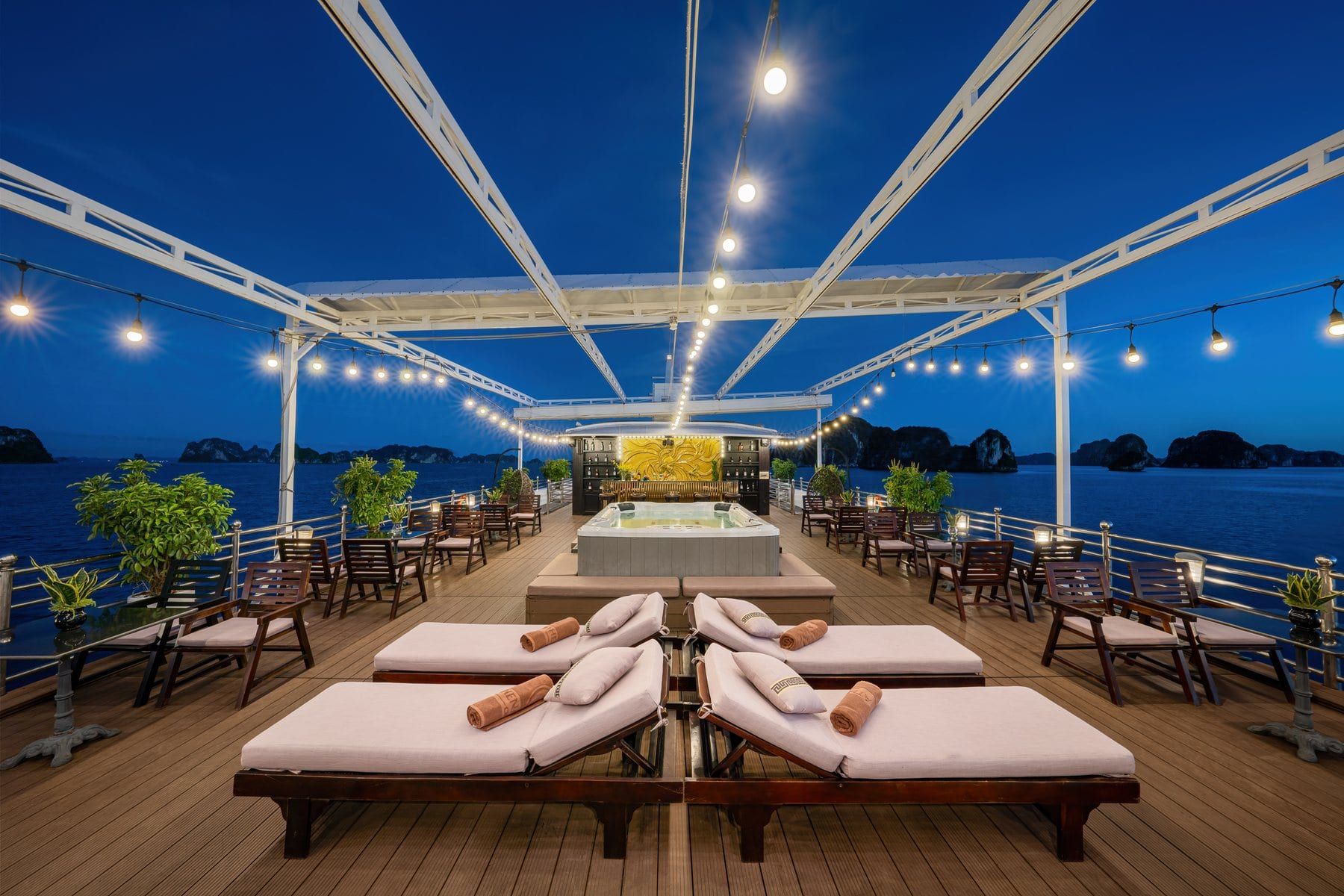 A sundeck at dusk beneath festoon lights