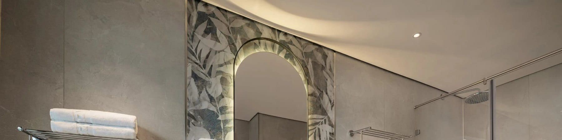 An Azura Cruise bathroom, arched mirror and walk-in rain shower