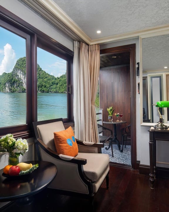 An Elegance cabin aboard Athena Luxury with an armchair at the window