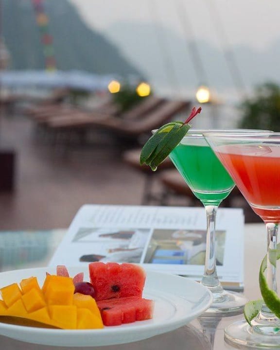 Two cocktails and a plate of tropical fruit on the Signature Halong sundeck